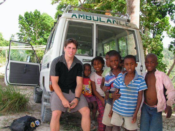 Matt in Haiti smiling with a group of children