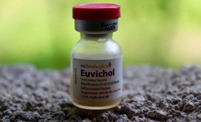 A close-up of a small vial of Euvichol oral cholera vaccine.