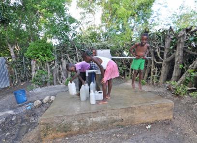 Group of children pumping water into containers