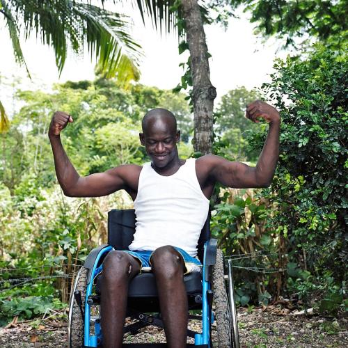 Man in wheelchair flexing his muscles